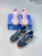 Pink and black Adidas Gazelle sneakers shown together in two colorways with Adidas boxes.