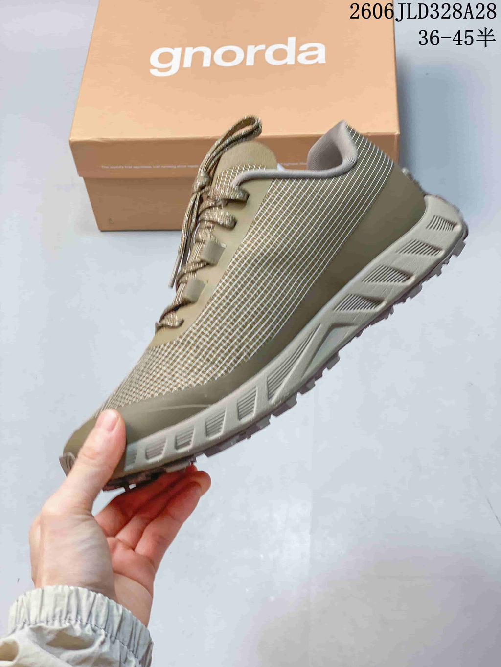 Side view of an olive NORDA hiking shoe with patterned upper, laces, and treaded outsole.