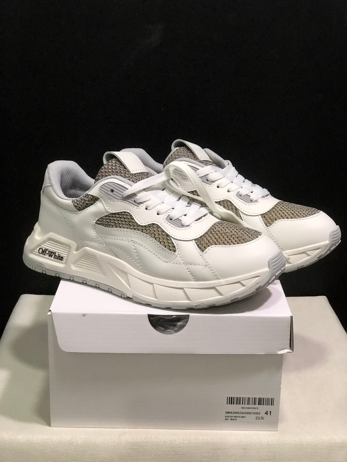 Pair of white and grey low-top sneakers displayed on a shoebox; the box label shows size 41.
