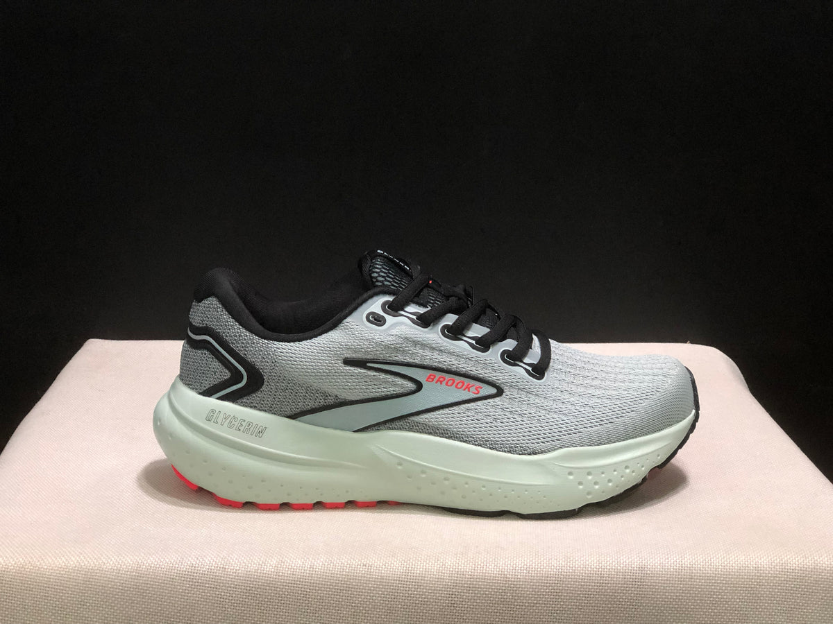 Single side profile of the gray Brooks Glycerin 21 sneaker with black trim and red outsole accents.