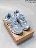 Pair of silver and light blue ASICS GEL-KAYANO 14 sneakers displayed on a shoebox.