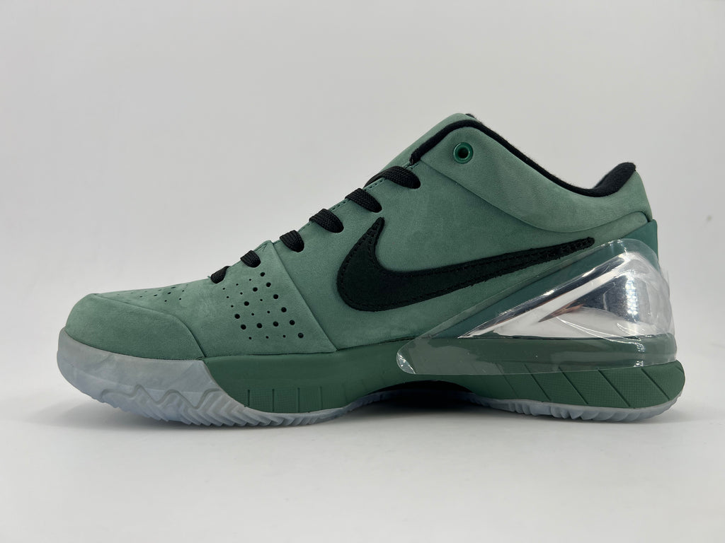 Side profile of the green low-top shoe with black Swoosh and clear heel accent
