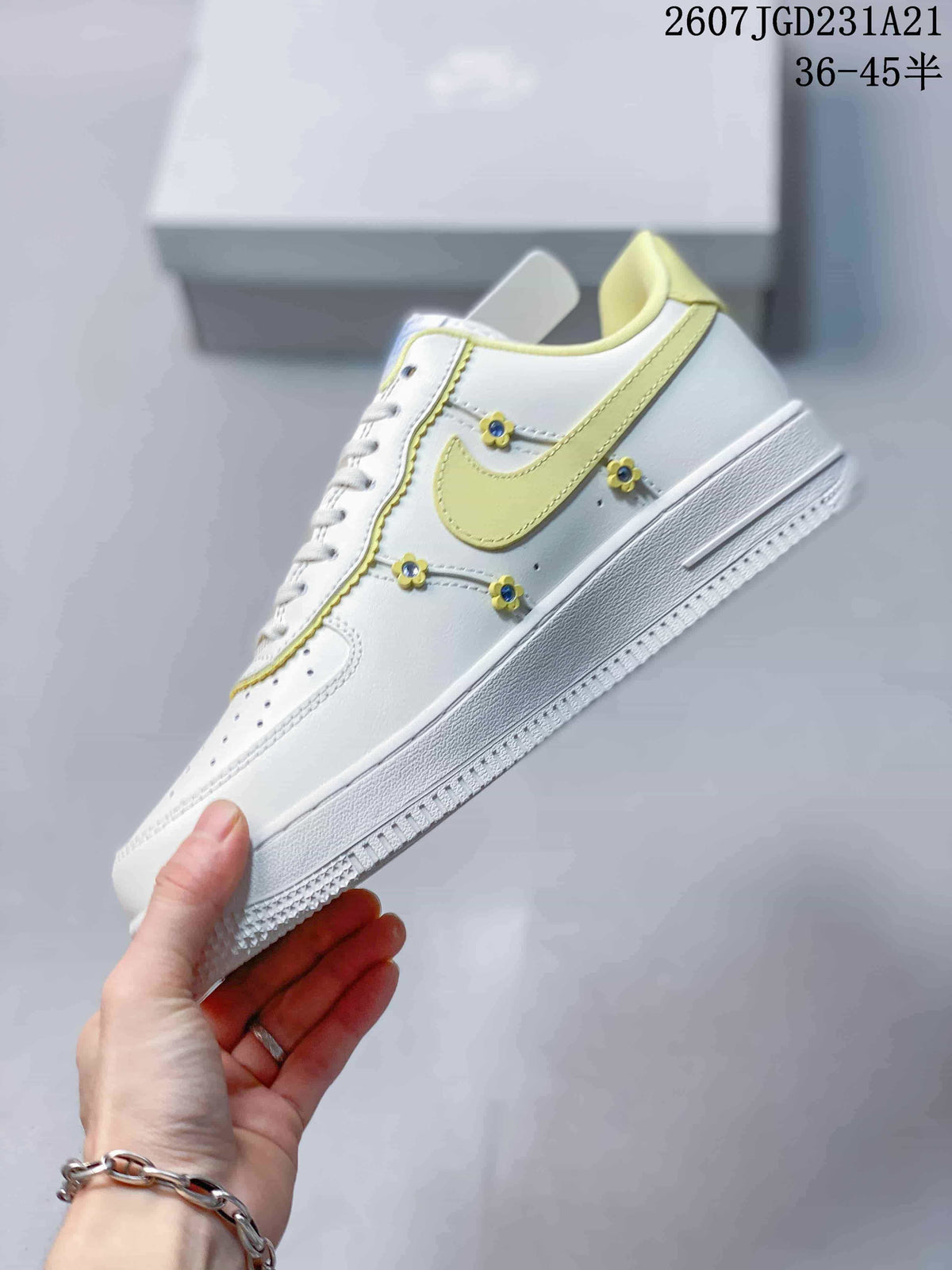 Side view showing the pale yellow Swoosh, white upper and small flower-shaped decorative details.