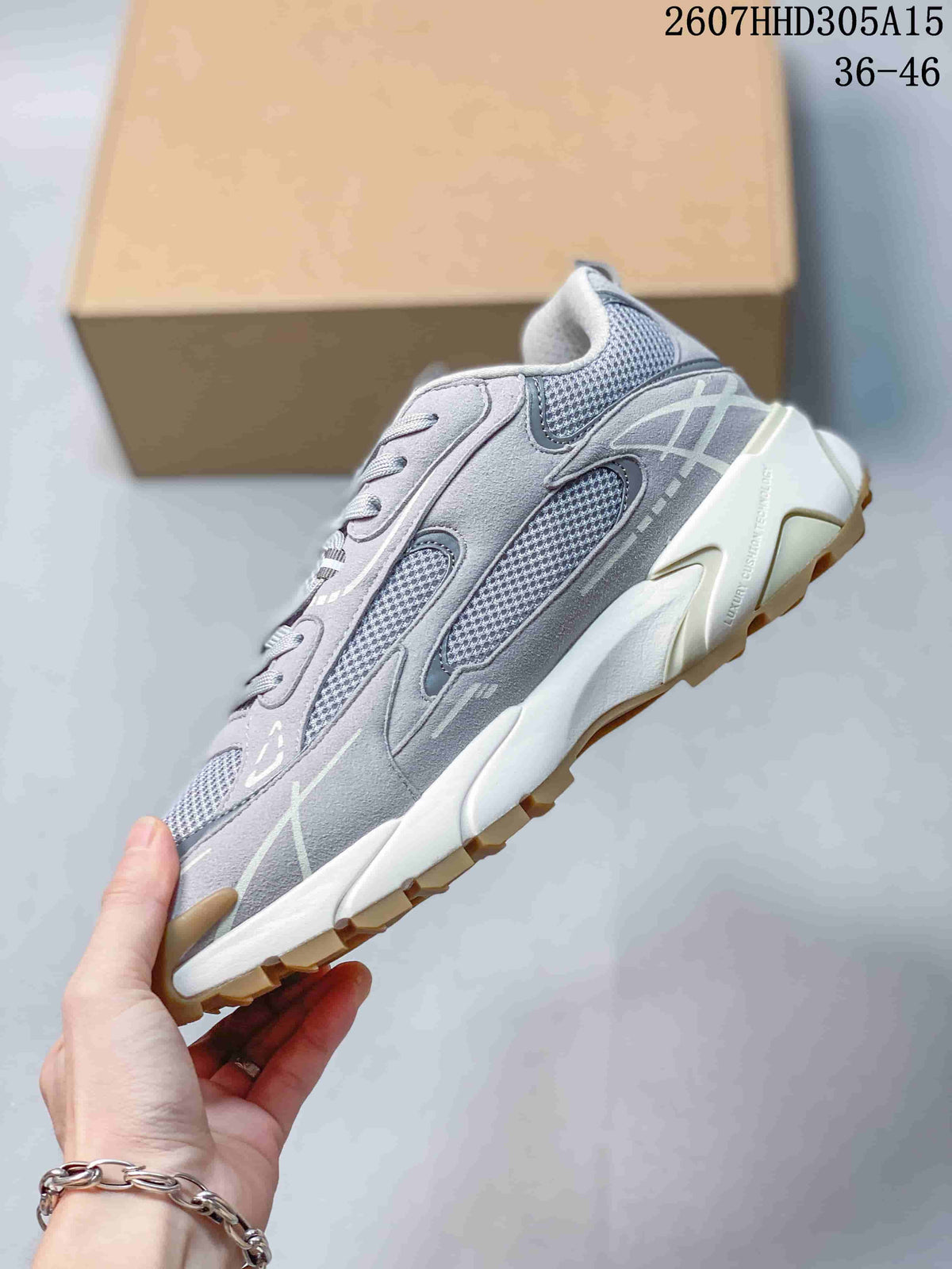 Side profile of the gray sneaker showing mesh panels, layered overlays, chunky white midsole, and tan outsole.