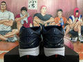 Rear view of dark Nike basketball shoes with patterned collars, white midsoles, and red outsole details