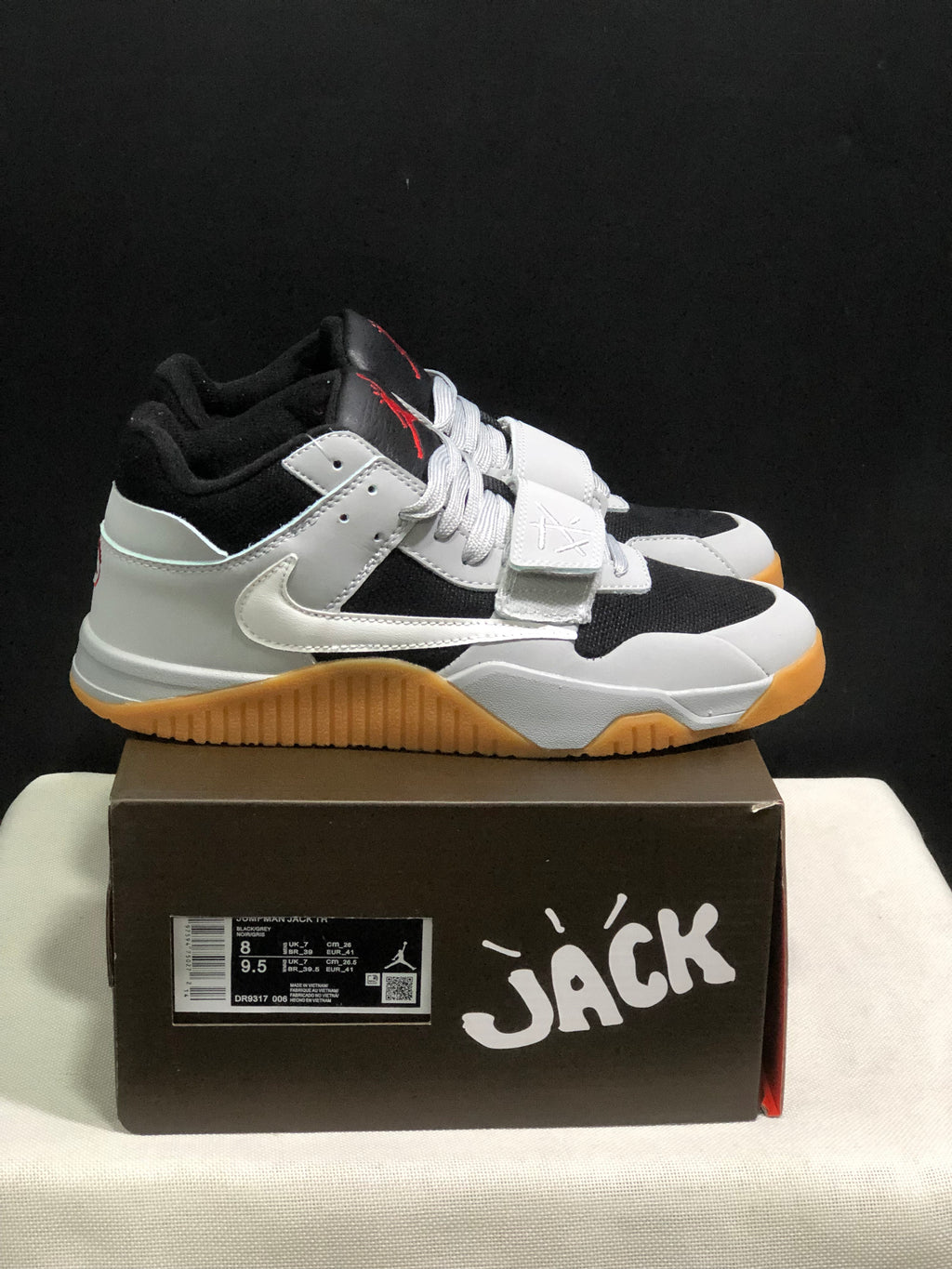 Side view of the black and white sneakers showing the forefoot strap, side Swoosh, and gum-colored outsole.
