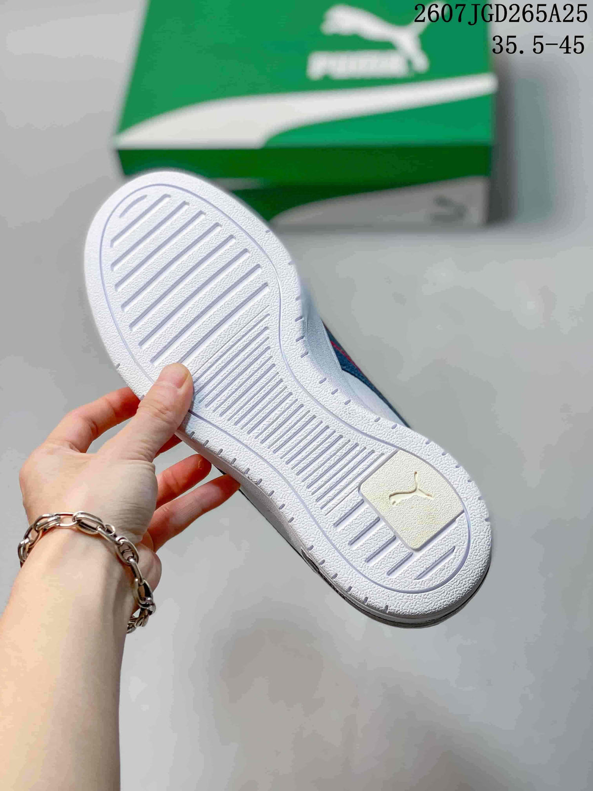 Outsole view of a white PUMA sneaker showing the textured tread pattern and molded heel detail.