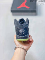 Rear view of the dark high-top sneaker showing the padded collar, heel branding, and lime-green outsole edge.