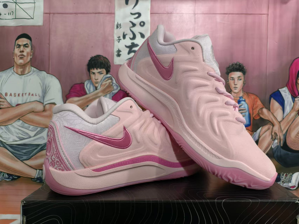 Pair of pink Nike basketball shoes shown from the side, highlighting the Swoosh and embroidered heel.