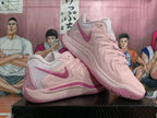 Pair of pink Nike basketball shoes shown from the side, highlighting the Swoosh and embroidered heel.