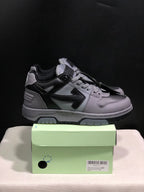 Side view of the grey and black low-top sneakers showing the layered side panels and padded collar.