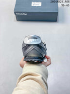 Rear view of the gray and silver sneaker showing the branded heel tab, outsole, and shoebox.