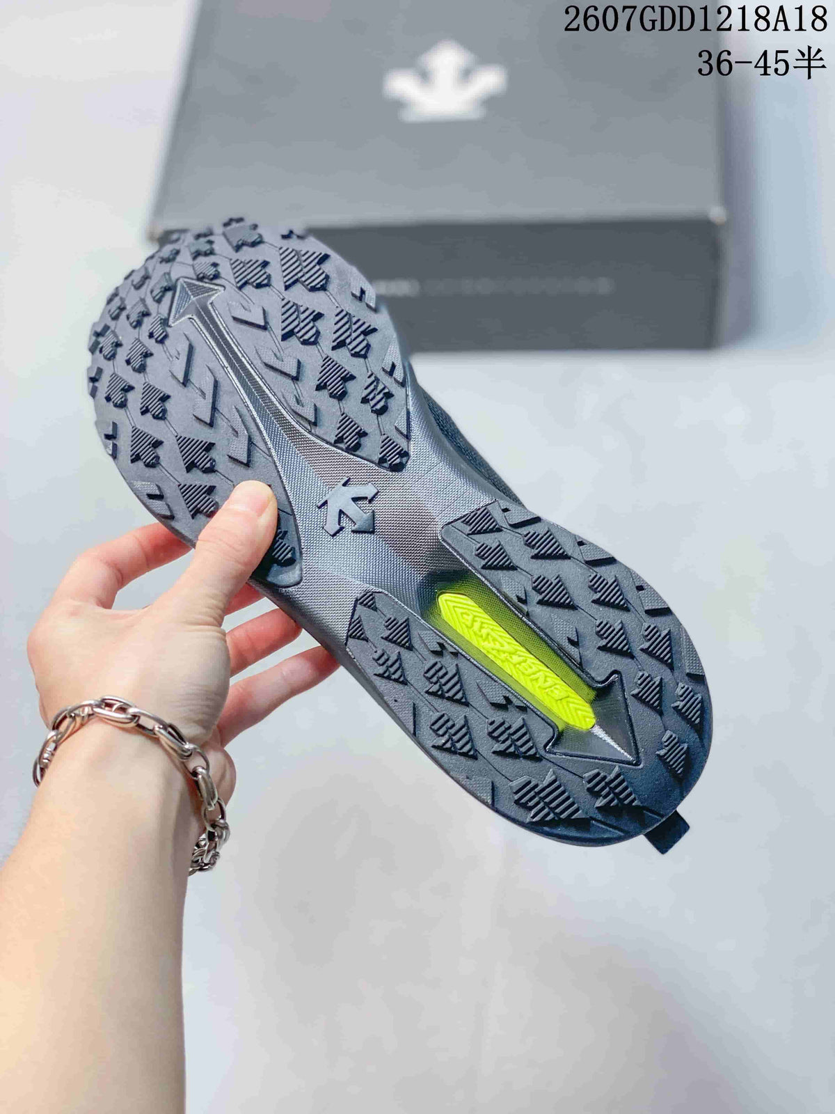 Outsole view showing the shoe's textured lugged tread and contrasting lime-green insert.