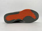 Underside showing a gray and orange outsole with a herringbone tread pattern