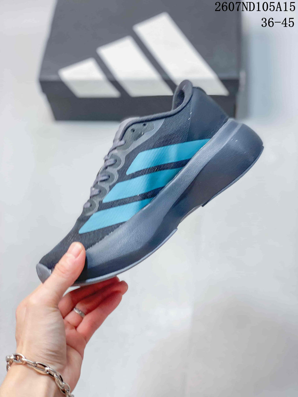 Side profile of the low-top sneaker showing its dark gray upper, bright blue stripes and raised sole.