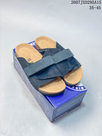 Pair of dark crossover sandals displayed on a Birkenstock-branded box, with the product code and size range visible above.