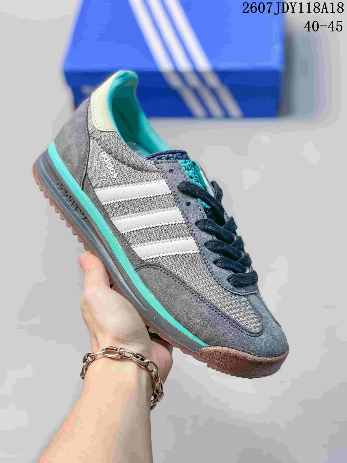 Gray adidas SL 72 sneaker with white stripes, turquoise accents and a brown outsole.