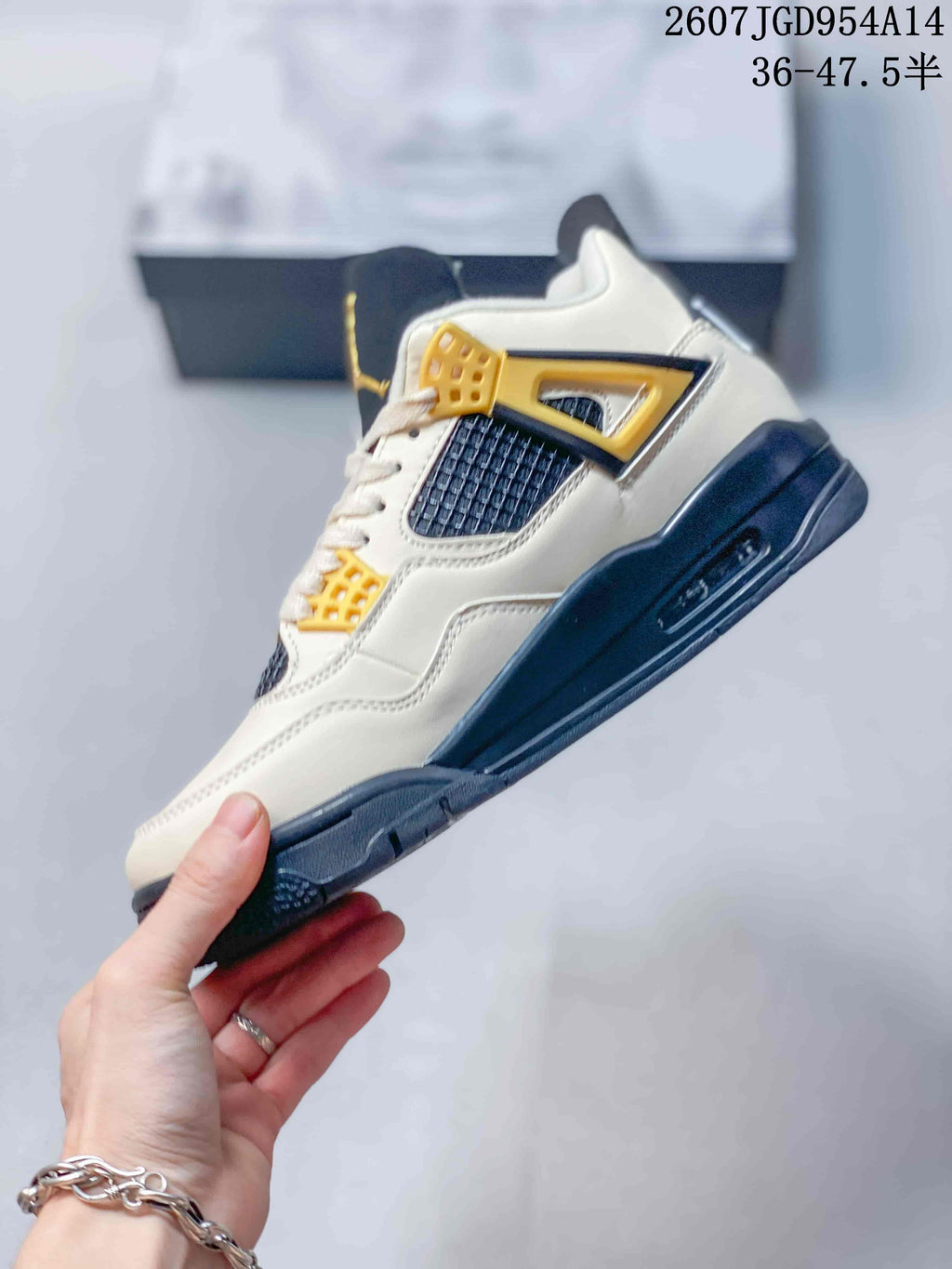Side profile highlighting the off-white upper, navy mesh panel, gold eyelet supports, and dark midsole.