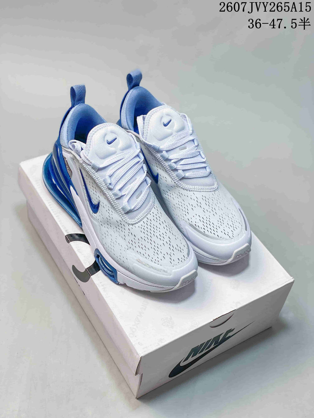 Pair of white and blue Nike Air Max 270 sneakers displayed on a Nike shoebox.