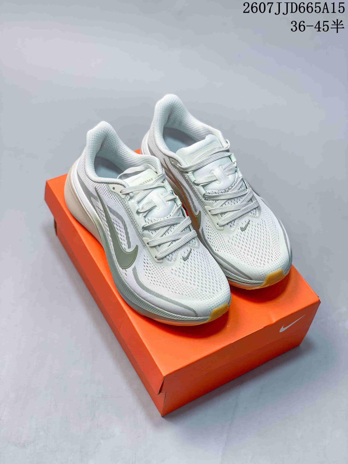Pair of light-colored Nike Pegasus 42 sneakers displayed on an orange shoebox, with green accents and gum-colored outsole edges.