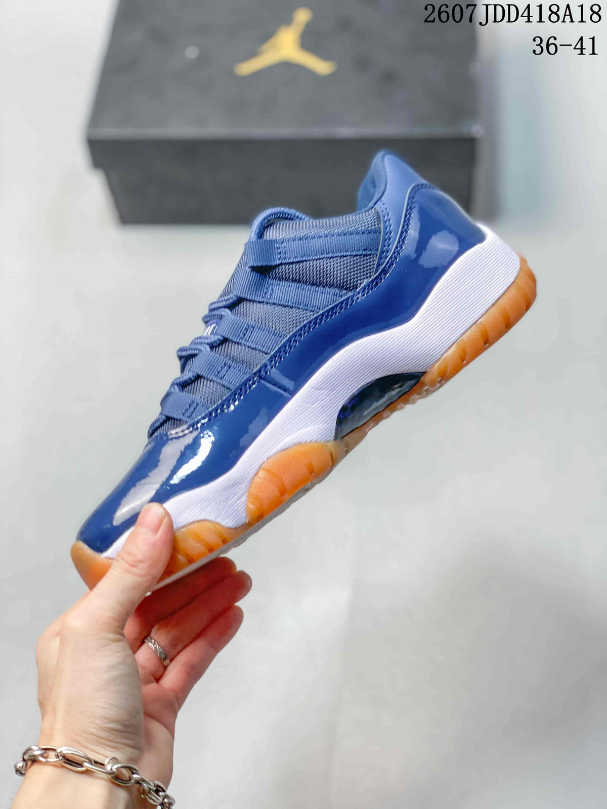 Side profile of the blue high-top sneaker showing the glossy upper, mesh sections, white midsole, and orange outsole.