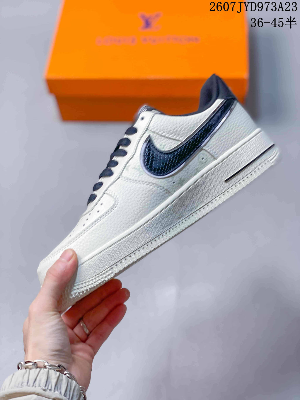 Side profile showing the white low-top sneaker, dark textured Swoosh, white midsole, and navy collar trim.
