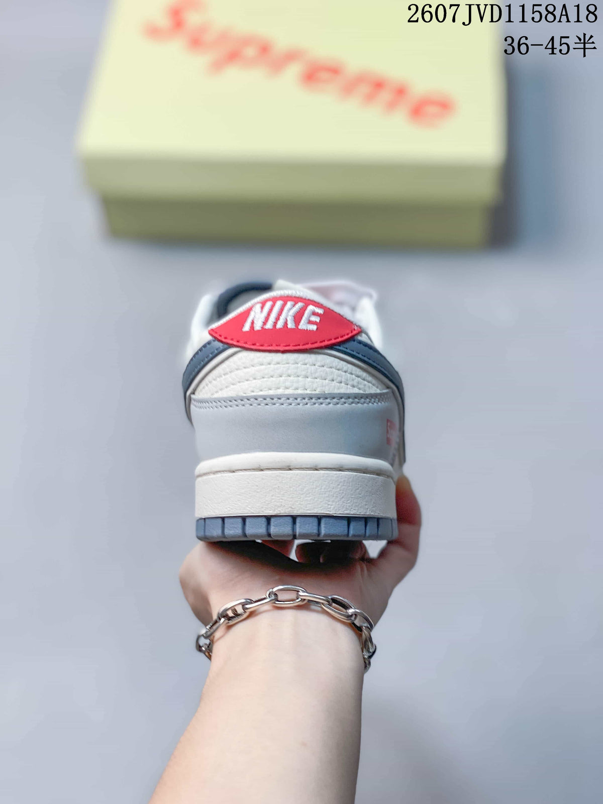 Rear view of the sneaker showing the padded heel, red tongue detail, layered upper, and gray outsole.