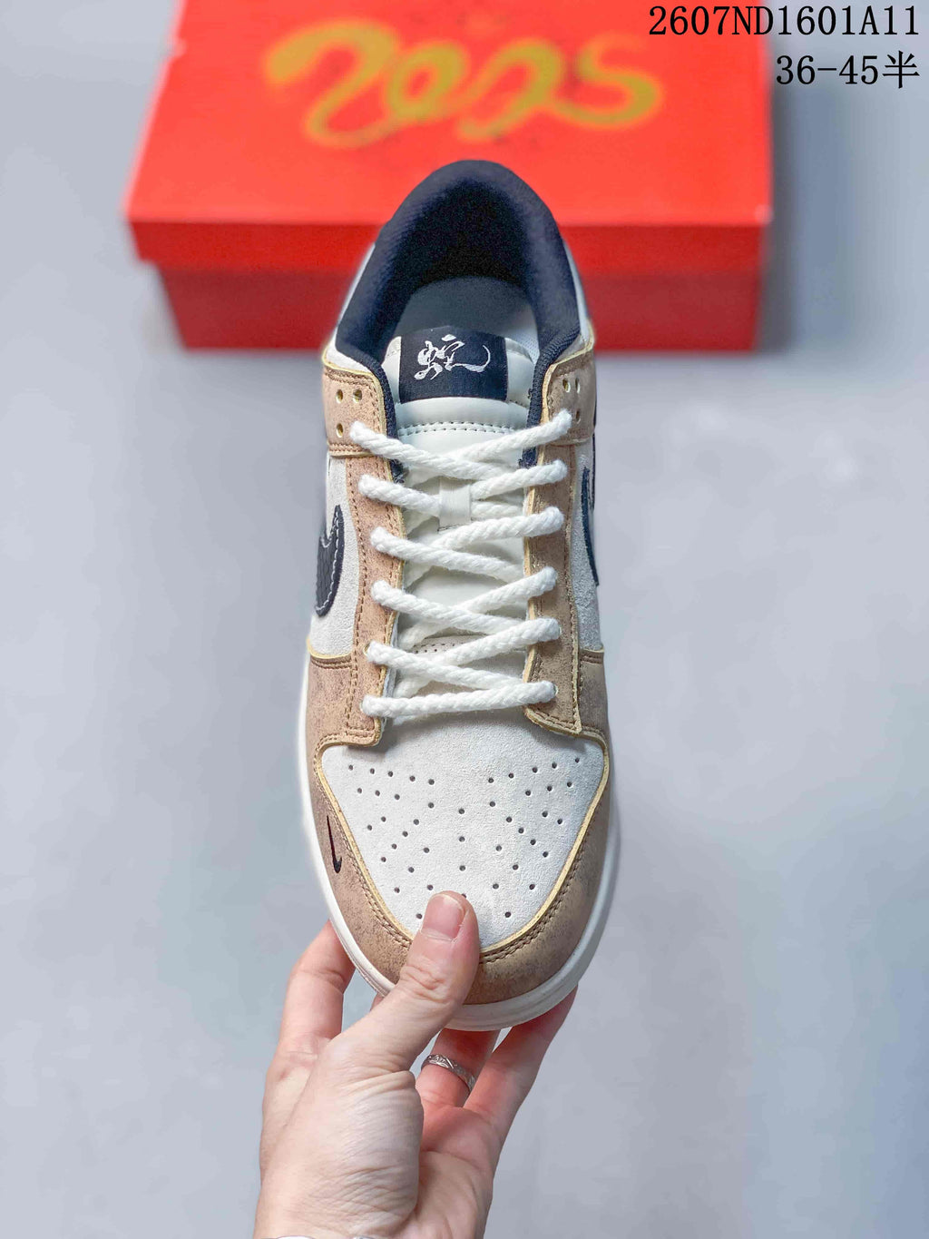 Top view showing white laces, a perforated white toe box, tan overlays, and a dark tongue label.