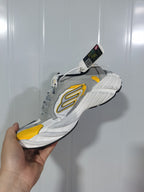 Close three-quarter view of the sneaker showing the layered sole, yellow toe accent, and side branding.
