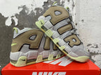 Pair of gray and brown Nike sneakers with oversized AIR lettering and light lime accents.