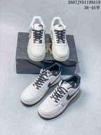 Multiple views of the white Nike sneaker pair showing perforated toe boxes, dark laces, contrasting Swooshes, patterned panels, and decorative lace accessories.