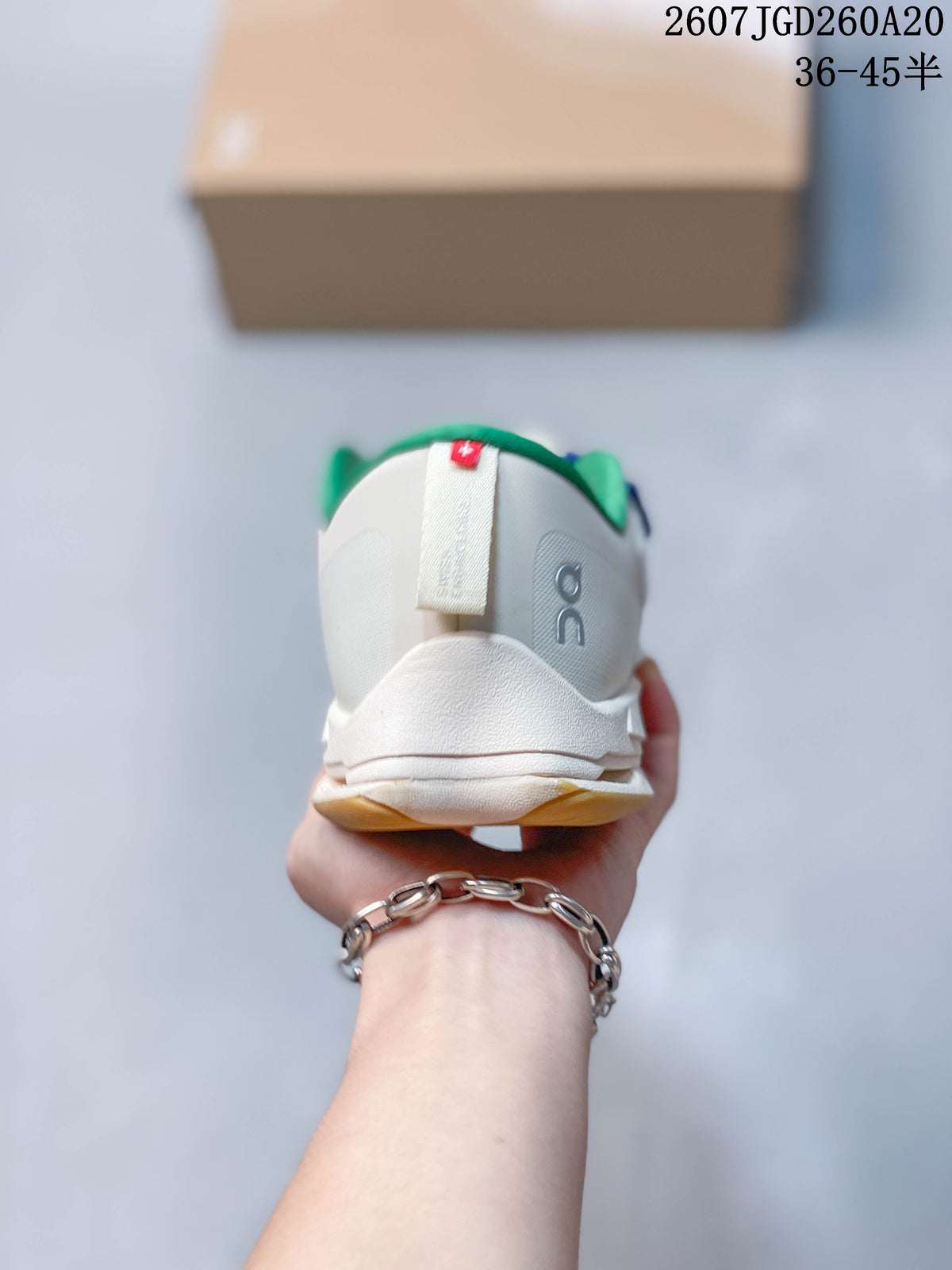Rear view of the white sneaker showing the green collar lining, heel pull tab, and On branding.
