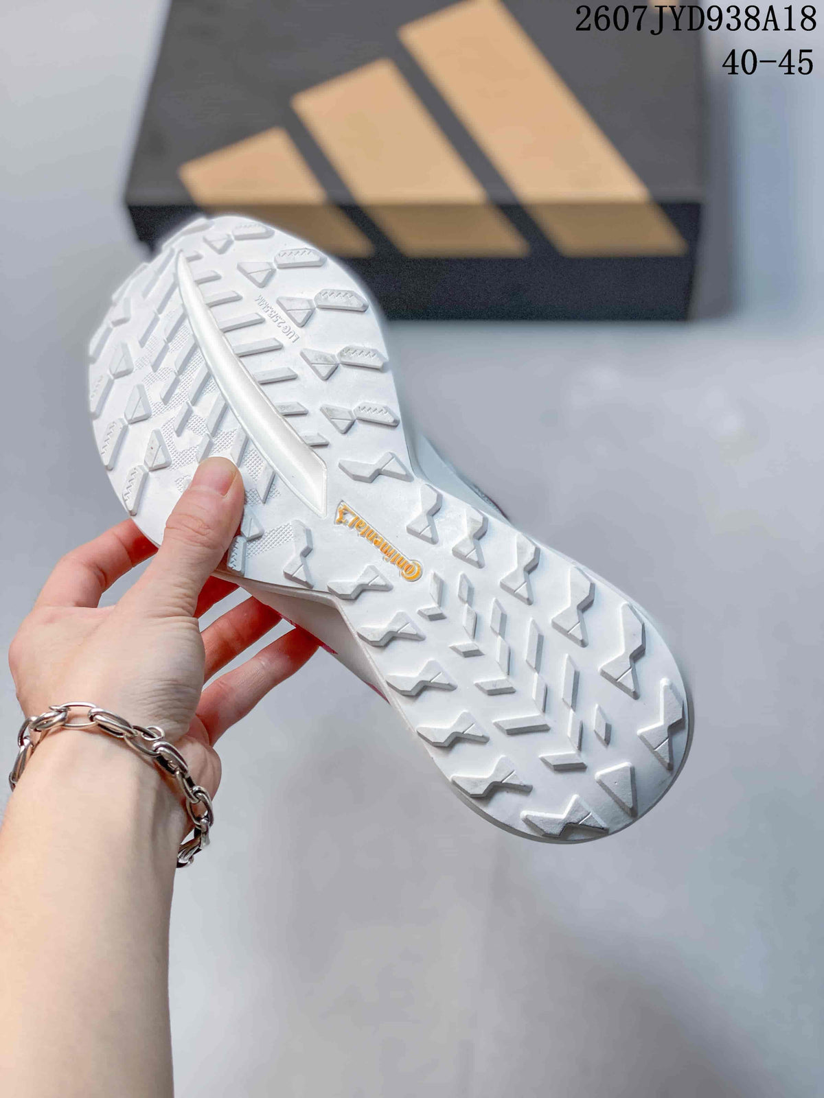 Close view of the white outsole showing raised geometric traction sections and a central branded marking.