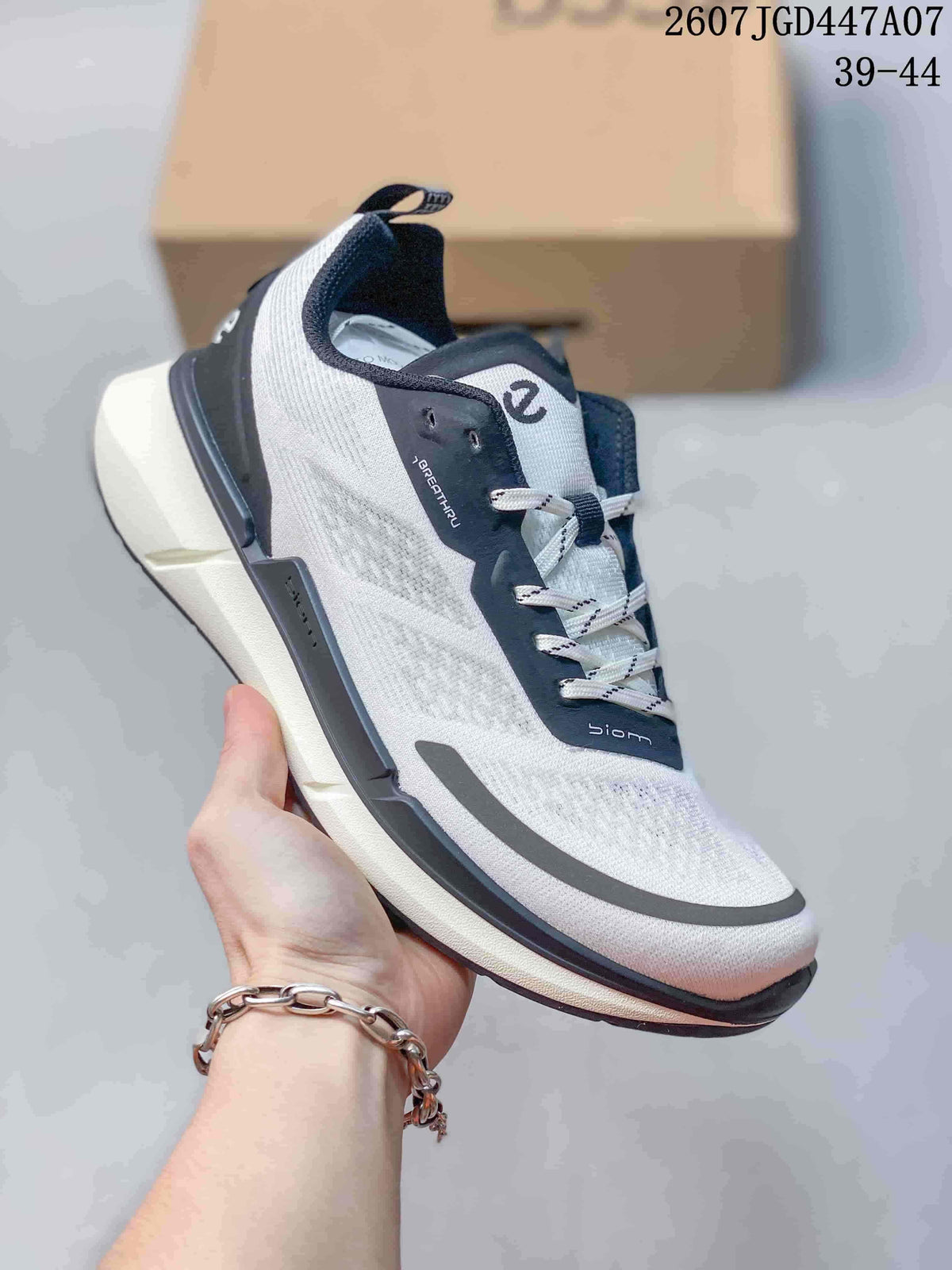 Angled side view of the sneaker showing the white textured upper, navy overlays, gray toe accent, and pull tab.