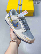 Side view of a white and gray low-top sneaker with navy and yellow accents