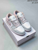 White and pale pink Jordan 1 Low sneakers shown from the front on a shoe box.