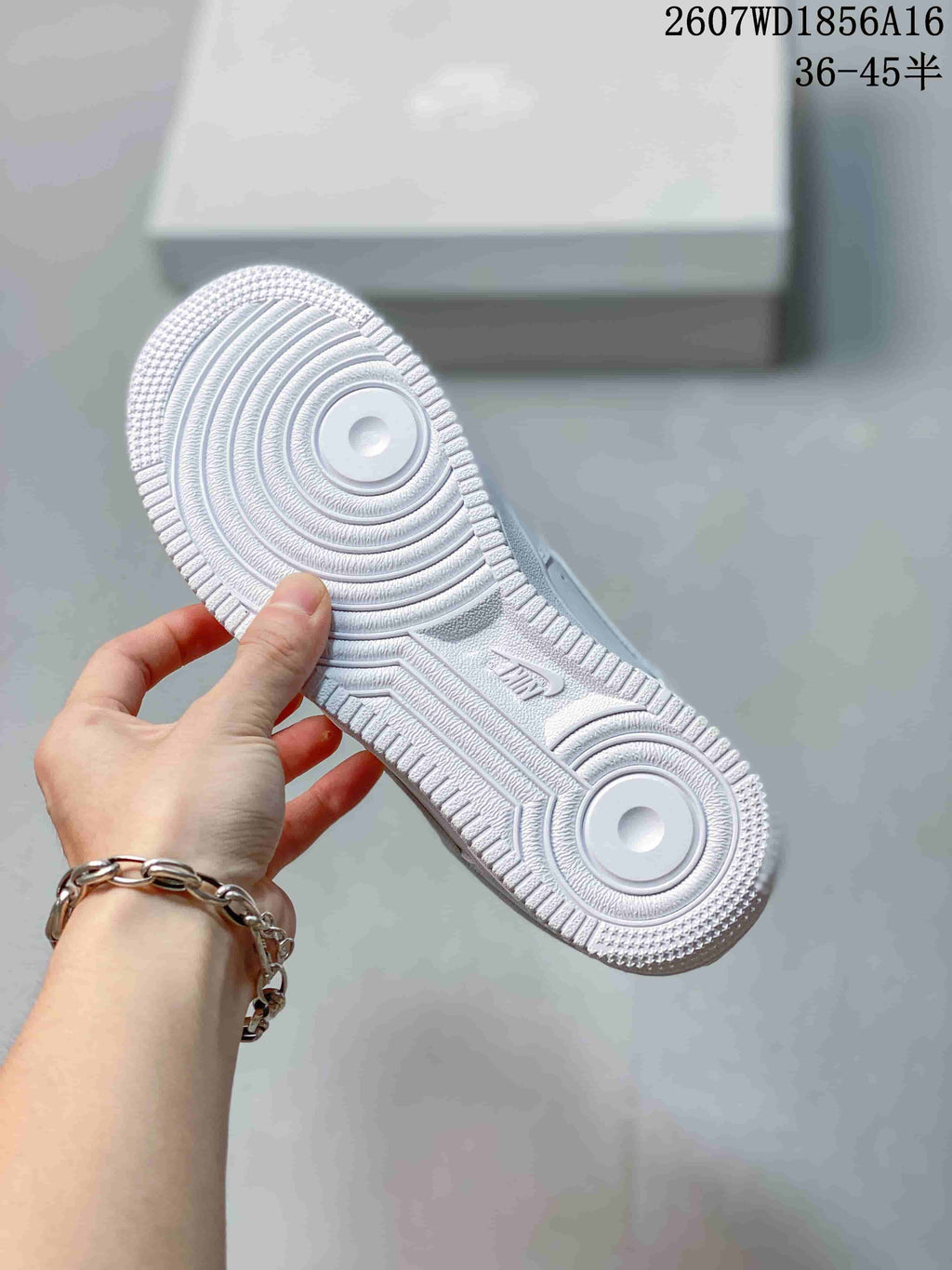 Close view of the white outsole showing concentric circular tread details, textured edges, and an AIR marking.