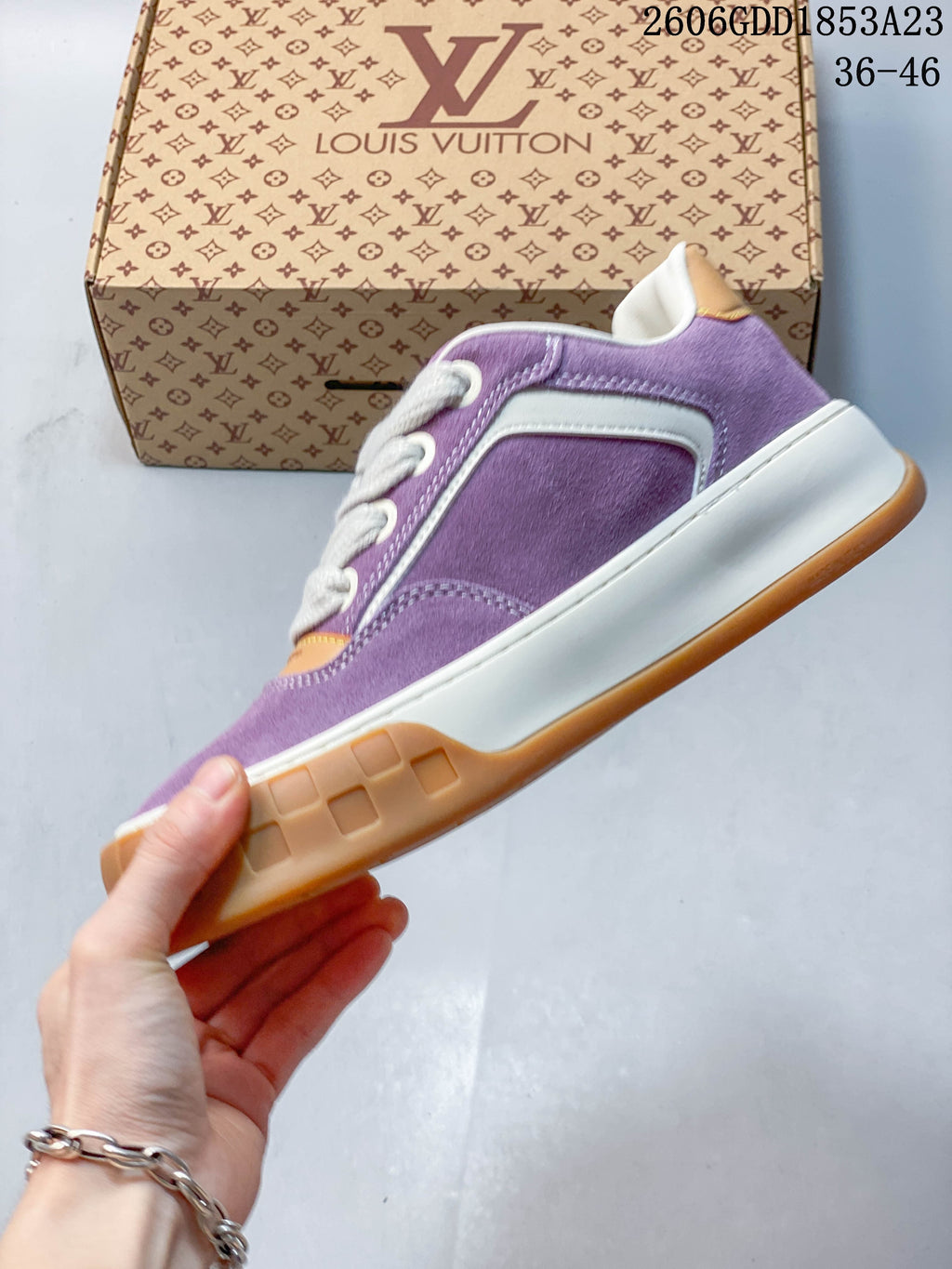 Side view of the purple low-top sneaker with white panel detailing and a gum-colored outsole.