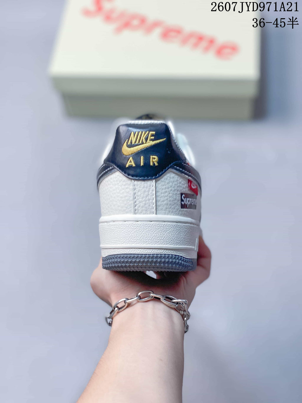 Rear view showing the padded heel, Nike Air tongue branding, navy heel accents and a visible side label.