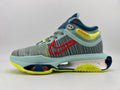 Side view of a gray patterned Nike shoe with red Swoosh detailing, pale blue overlays, navy accents, neon yellow details, and a sculpted sole.