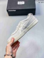 Side profile of a light gray ASICS Japan S sneaker showing the layered side stripes, low-top shape, and textured outsole.