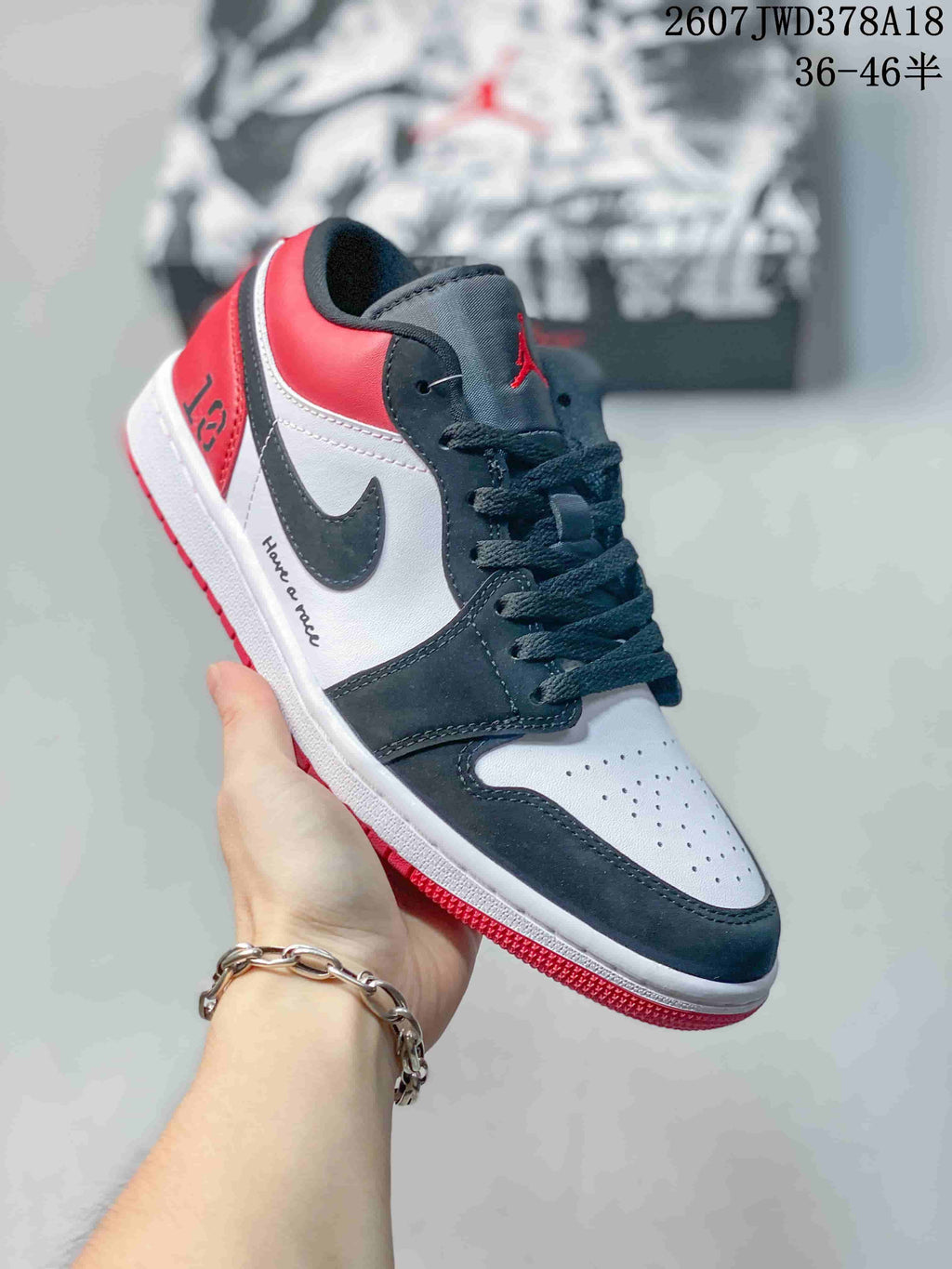 Angled side view showing the black and white upper, red heel, white midsole, and red outsole