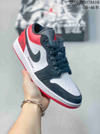 Angled side view showing the black and white upper, red heel, white midsole, and red outsole