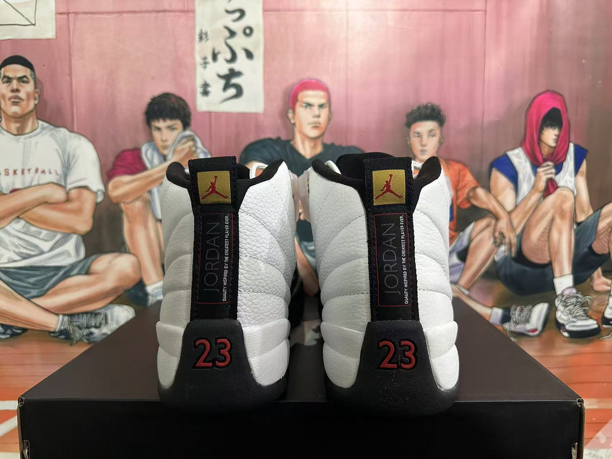 Rear view of white and black Jordan 12 sneakers with red number 23 details.