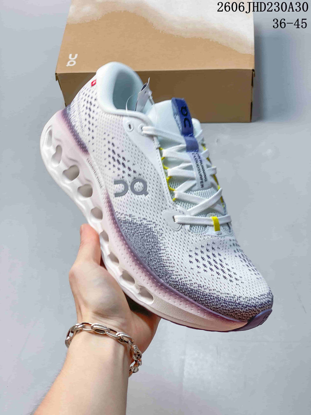 Close-up of a white On Cloudtilt shoe with purple and yellow accents and a sculpted sole.
