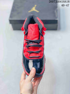 Top-down view showing the red tongue and lace area, black laces, and glossy black toe section.