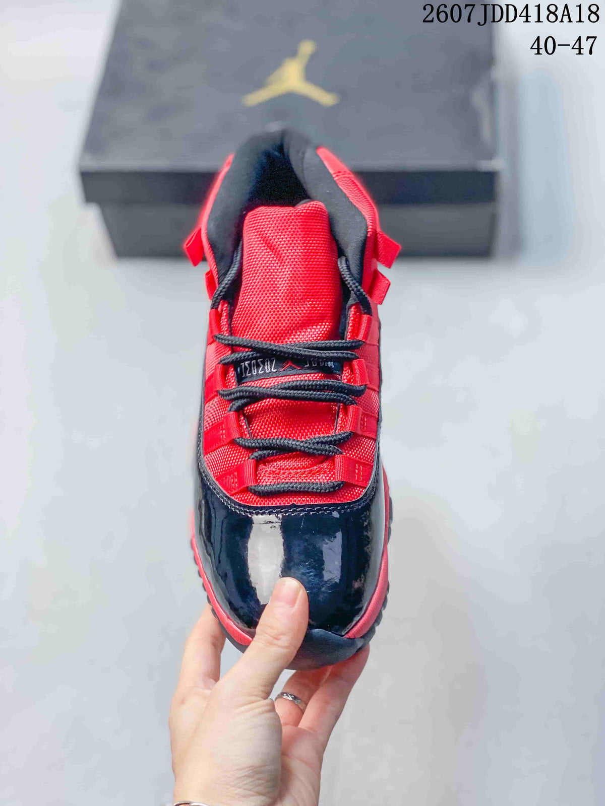 Top-down view showing the red tongue and lace area, black laces, and glossy black toe section.