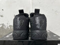 Rear view of black high-top basketball shoes with tonal heel graphics and sculpted soles.
