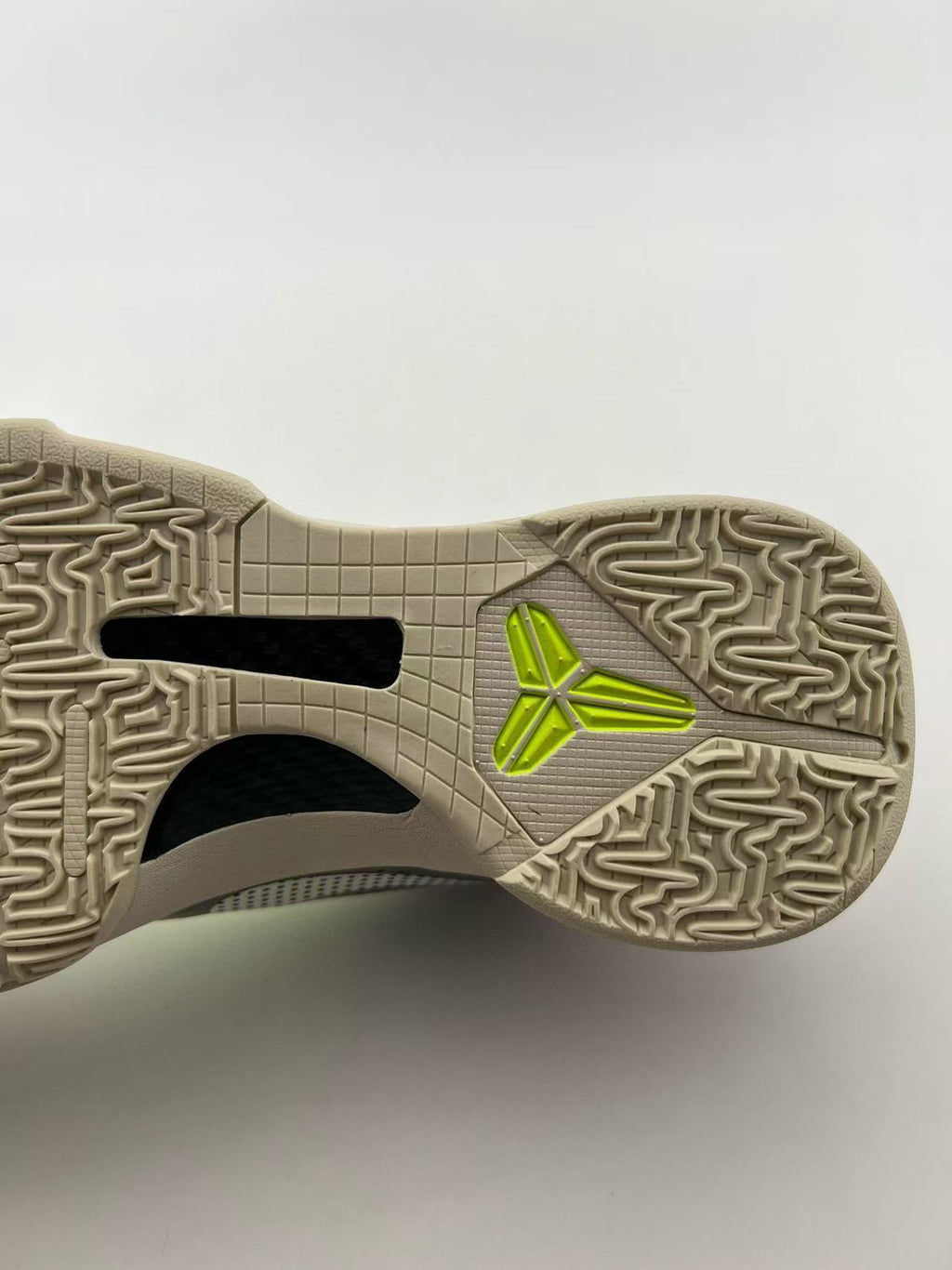 Close-up of the patterned outsole and neon yellow logo detail