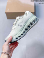 Side view of a white On sneaker showing the textile upper, side branding and sculpted open-channel outsole.